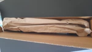 Emballage des posters dans une boite rectangulaire entouré de papier craft ajusté à la boite